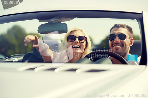 Image of happy man and woman driving in cabriolet car