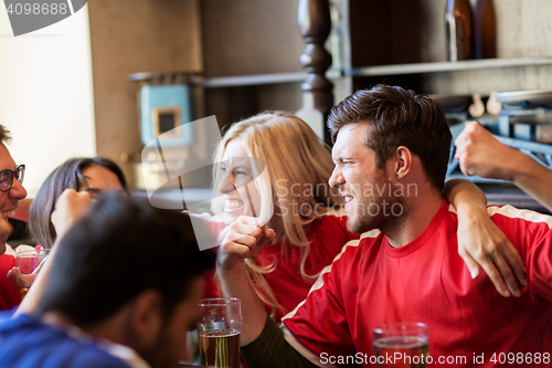 Image of football fans or friends with beer at sport bar