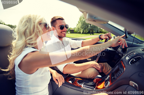 Image of happy couple using gps navigator in cabriolet car