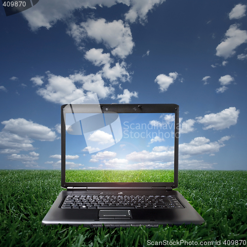 Image of Laptop on green grass on a sunny day