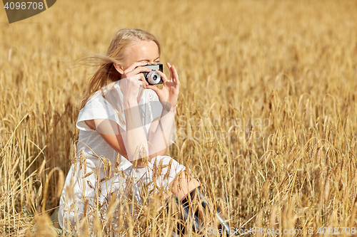 Image of woman taking picture with camera in cereal field