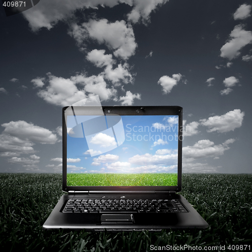 Image of Laptop on green grass on a sunny day