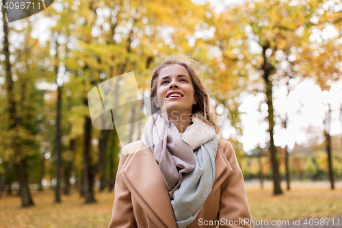 Image of beautiful happy young woman walking in autumn park
