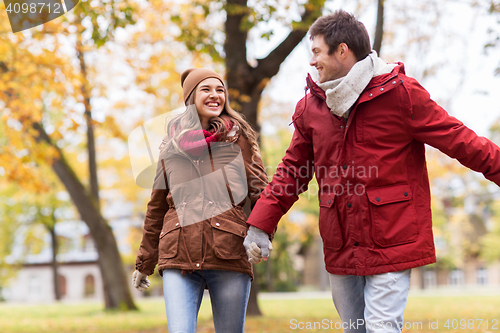 Image of happy young couple walking in autumn park