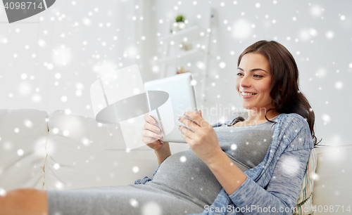 Image of happy pregnant woman with tablet pc at home