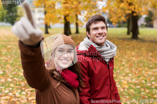 Image of happy young couple walking in autumn park