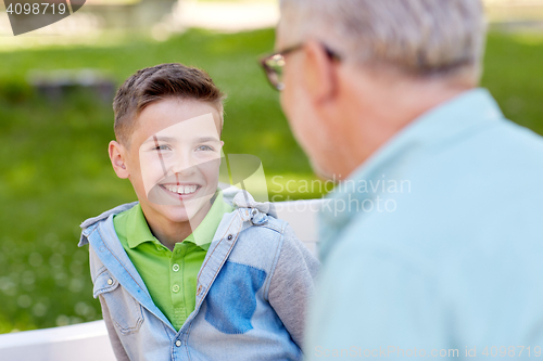 Image of grandfather and grandson talking at summer park