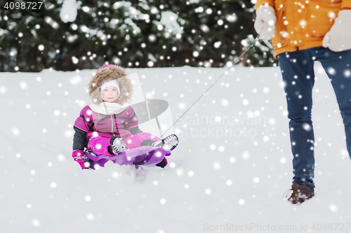 Image of happy little kid on sled outdoors in winter