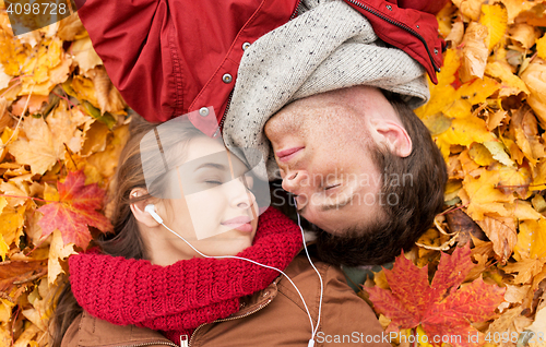 Image of close up of smiling couple lying in autumn park