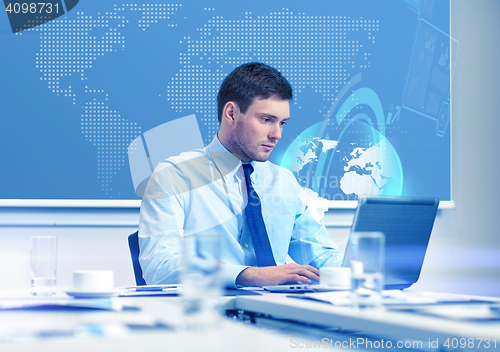 Image of businessman with laptop working in office