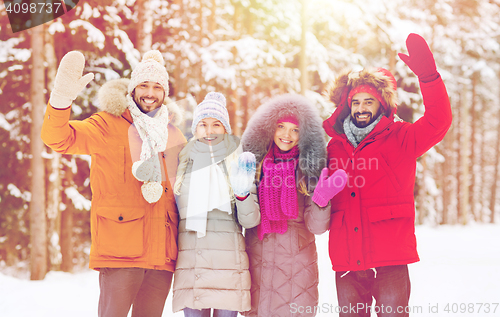 Image of group of friends waving hands in winter forest