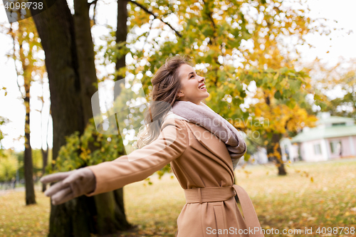 Image of beautiful happy young woman walking in autumn park