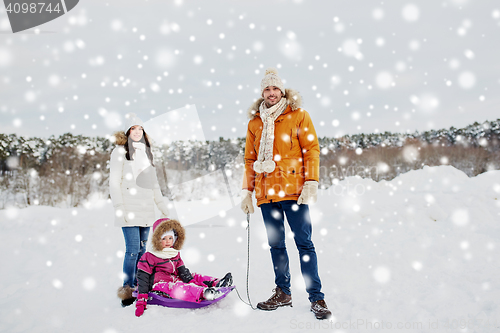 Image of happy family with sled walking in winter outdoors