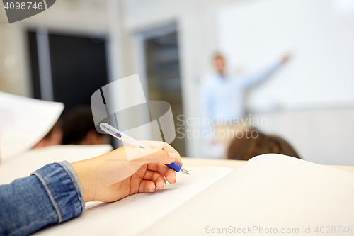 Image of student hand writing to notebook at lecture
