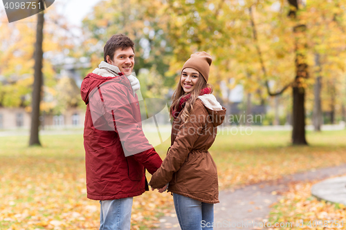 Image of happy young couple walking in autumn park