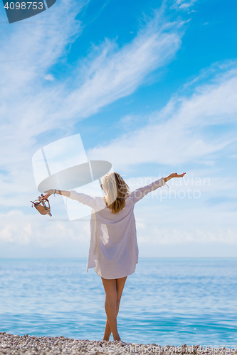 Image of portrait of young pretty woman looking to the ocean 