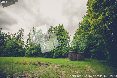 Image of Small wooden shed on a field