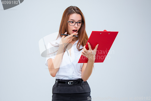 Image of The young business woman with pen and tablet for notes on gray background