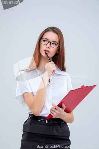 Image of The young business woman with pen and tablet for notes on gray background