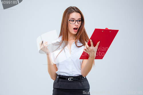 Image of The young business woman with pen and tablet for notes on gray background