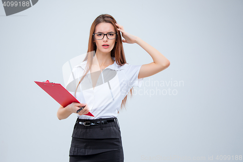 Image of The young business woman with pen and tablet for notes on gray background