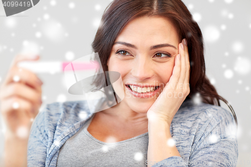 Image of happy woman looking at home pregnancy test