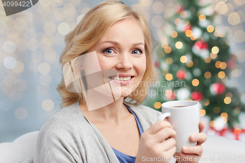 Image of happy woman with cup of tea or coffee at christmas