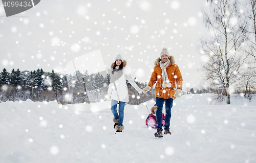 Image of happy family with sled walking in winter outdoors