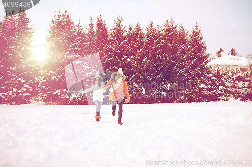 Image of happy couple running in winter snow