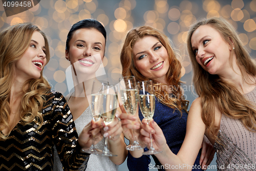 Image of happy women clinking champagne glasses over lights