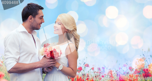 Image of happy couple with flowers over lights background