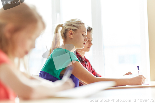 Image of group of students with books writing school test