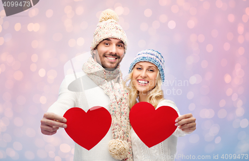 Image of smiling couple in winter clothes with red hearts