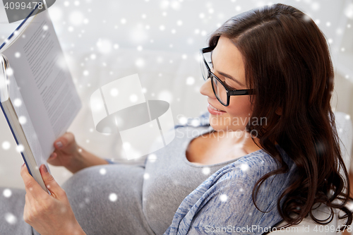 Image of happy pregnant woman reading book at home