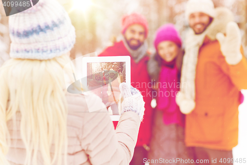 Image of happy friends with tablet pc in winter forest