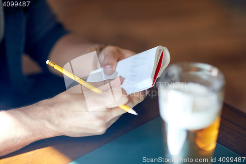 Image of close up of man with beer and notebook at pub