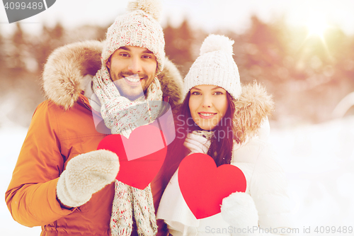 Image of happy couple with red hearts over winter landscape