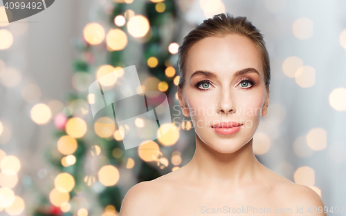 Image of beautiful woman face over christmas lights