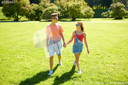 Image of happy teenage couple walking at summer park