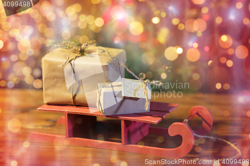 Image of close up of christmas gift boxes on wooden sleigh