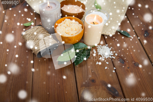 Image of natural body scrub and candles on wood