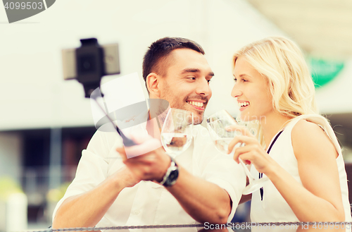 Image of happy couple taking selfie with smartphone at cafe