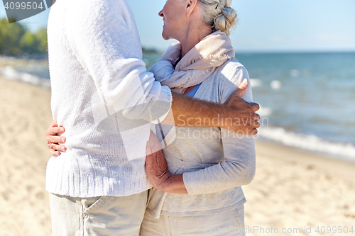 Image of close up of happy senior couple hugging on beach