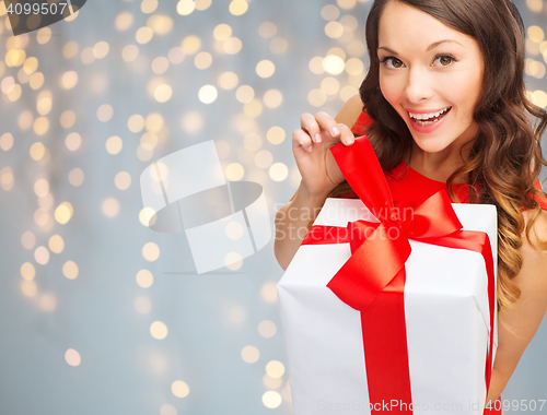 Image of smiling woman in red dress with gift box