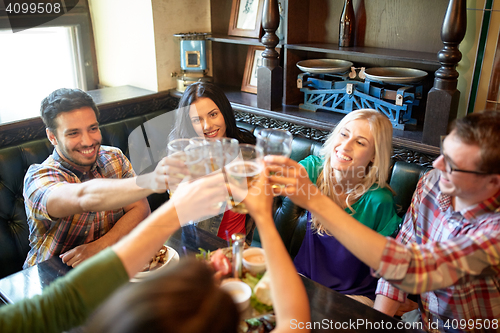 Image of happy friends drinking beer at bar or pub