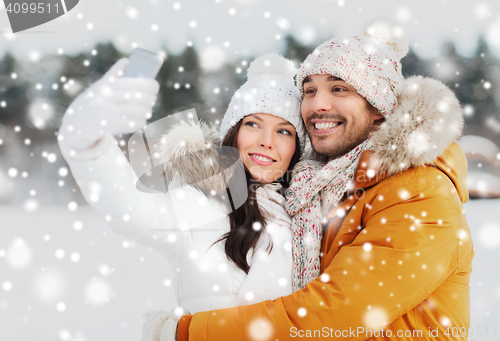 Image of happy couple taking selfie by smartphone in winter