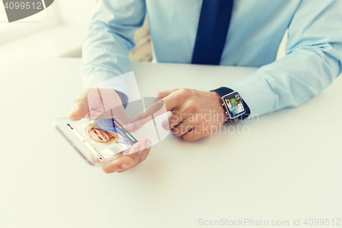 Image of close up of hands with smart phone and watch