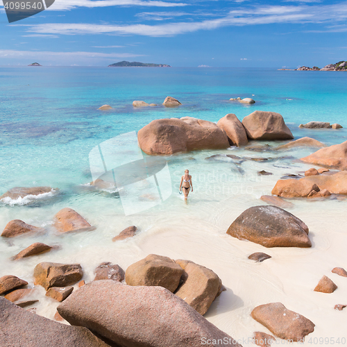 Image of Woman enjoying Anse Lazio picture perfect beach on Praslin Island, Seychelles.