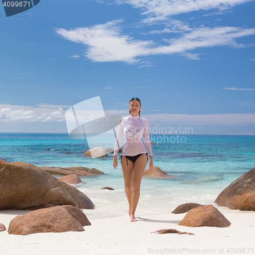 Image of Woman enjoying Anse Lazio picture perfect beach on Praslin Island, Seychelles.