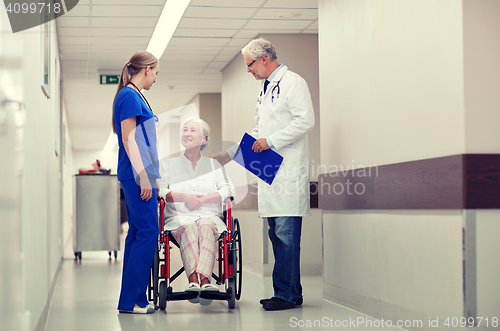 Image of medics and senior woman in wheelchair at hospital